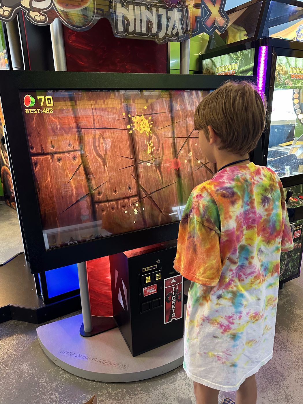 Kid playing the Ninja FX arcade game at Glow Games Twin Falls