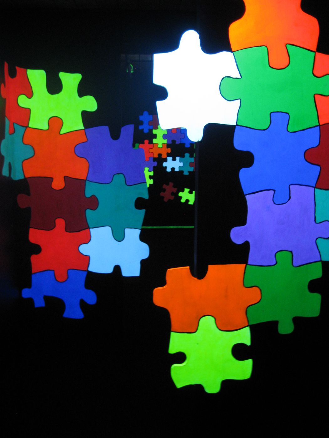 Glowing neon puzzle-piece art on the mini golf course at Glow Games Twin Falls